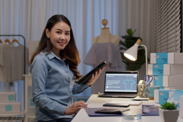 Young Asian woman using tablet to manage business